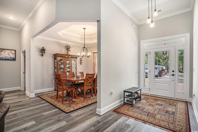 Entryway featuring wood finished floors, crown molding, a chandelier, baseboards, and recessed lighting | Image 4