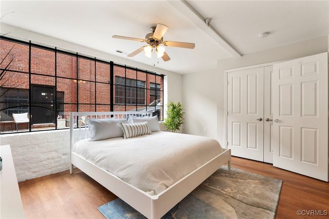 Bedroom featuring multiple windows, wood finished floors, a closet, and a ceiling fan | Image 13