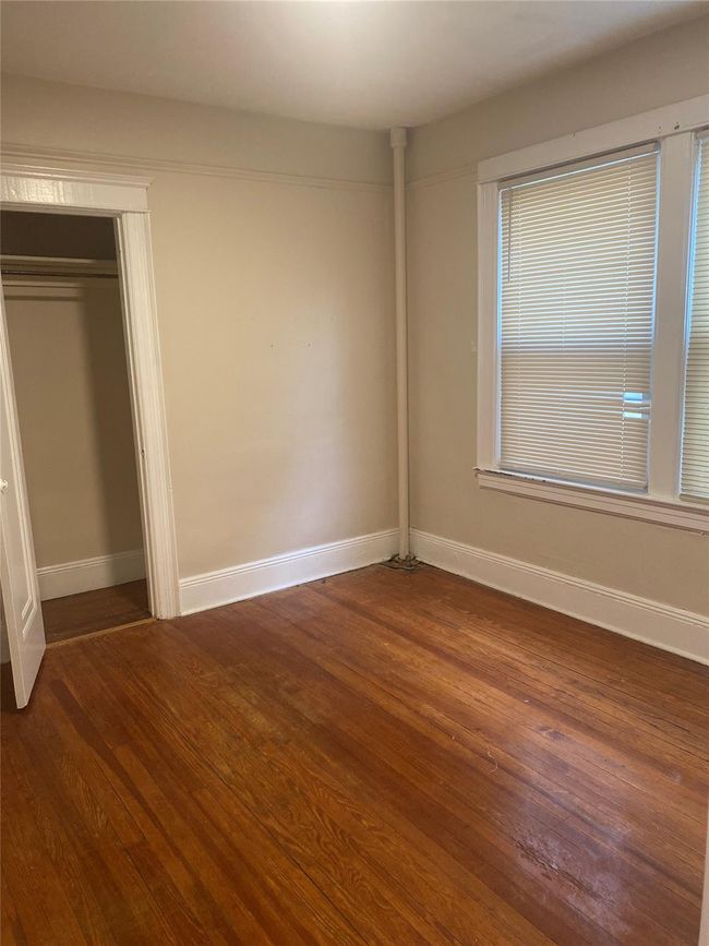 Unfurnished bedroom with dark wood finished floors and a closet | Image 4