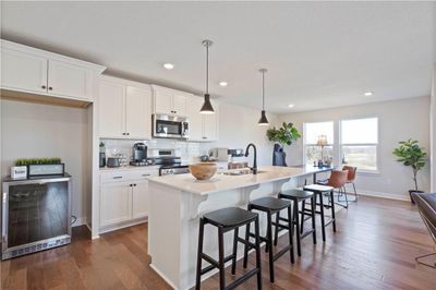 Kitchen with a kitchen island with sink, sink, stainless steel appliances, and hardwood / wood-style flooring | Image 3