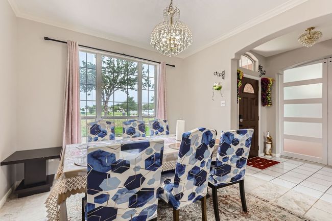 Dining room featuring arched walkways, a chandelier, ornamental molding, and light tile patterned floors | Image 8