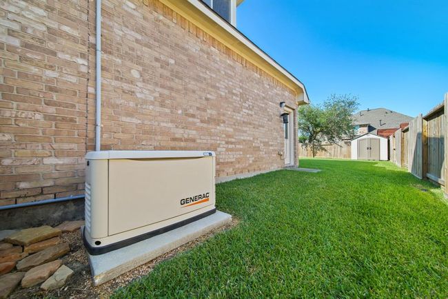 You will be the envy of the neighborhood should your home lose power with a Generac whole home generator included in the sale of this home. Don't miss the convenient glass door offering access to the home's 3-car attached garage from the backyard. | Image 48