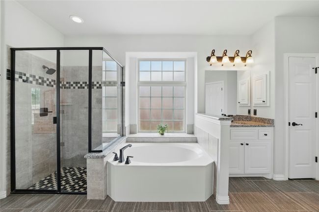 Full bathroom with a bath, a shower stall, vanity, wood finish floors, and recessed lighting | Image 23