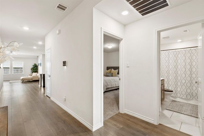 Corridor with baseboards, wood finished floors, and visible vents | Image 14