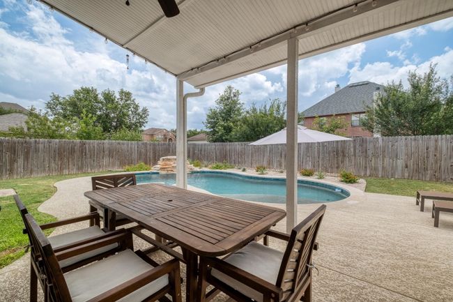 Fenced backyard with outdoor dining area, a patio, and a ceiling fan | Image 31