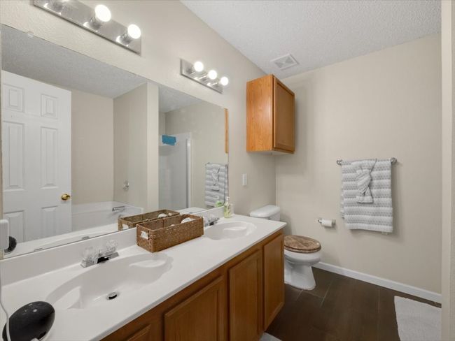 Full bathroom featuring a textured ceiling, toilet, vanity, and separate shower and tub | Image 18