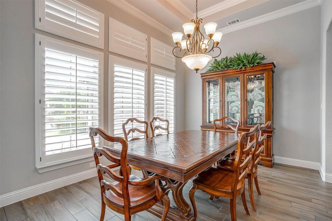 Dining room with plenty of natural light, a chandelier, ornamental molding, and light wood finished floors | Image 9