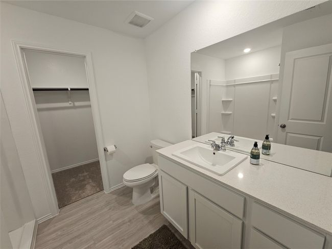 Bathroom with vanity, toilet, baseboards, wood finished floors, and a spacious closet | Image 16