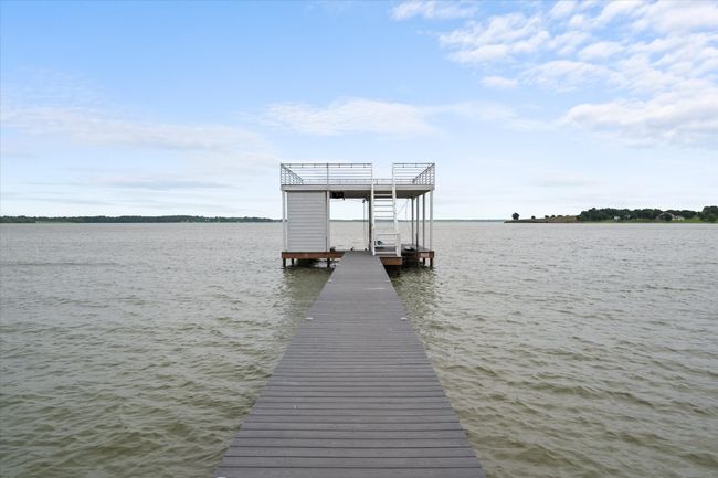 Dock area featuring boat lift and a water view | Image 32