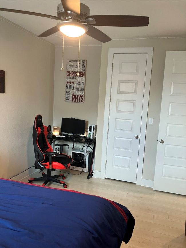 Bedroom featuring light wood finished floors, a desk, baseboards, and ceiling fan | Image 18