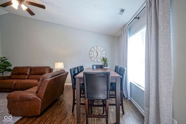 dining area featuring a ceiling fan, visible vents, vaulted ceiling, and dark wood finished floors | Image 10