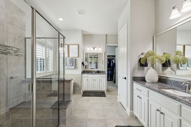 Bathroom featuring two vanities, a shower stall, tile patterned flooring, and a walk in closet | Image 21