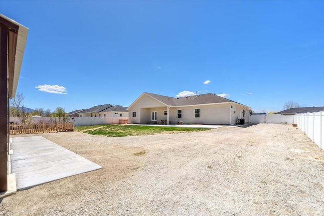 Back of house with stucco siding, a fenced backyard, and a patio | Image 58