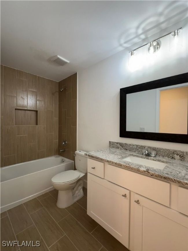 Full bathroom with toilet, tiled shower / bath combo, and vanity | Image 7