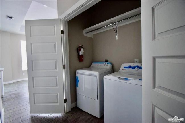 Washroom with washing machine and clothes dryer and wood finish floors | Image 6