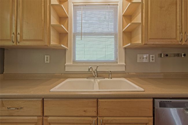 Kitchen with dishwasher, light countertops, open shelves, and light brown cabinets | Image 17