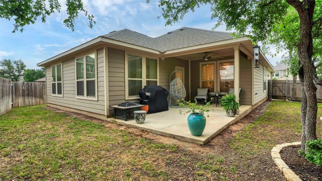 Rear view of house featuring ceiling fan, a fenced backyard, a yard, a patio, and a shingled roof | Image 29