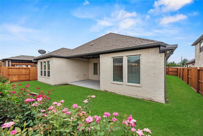 Things are really blooming in Heritage at Towne Lake! Enjoy the beauty of this vibrant backyard, complete with colorful flowers, a lush lawn, a full sprinkler system and a covered patio, perfect for morning coffee, weekend grilling, or simply soaking up the sunshine in your own private outdoor retreat. | Image 39