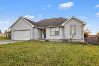 Ranch home featuring a garage and a front yard | Image 1