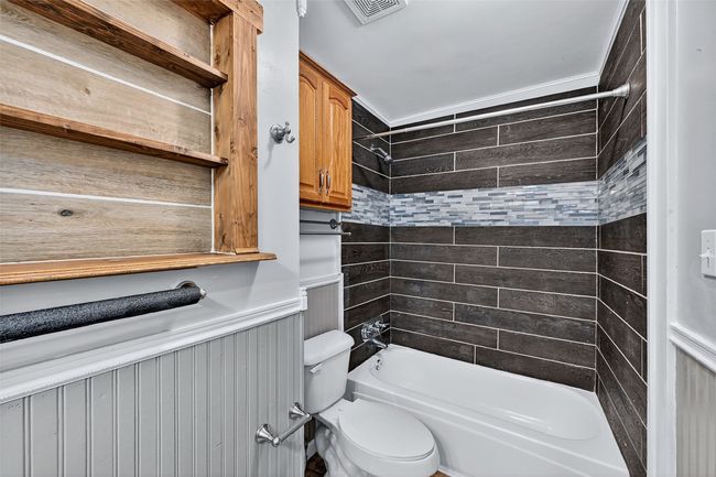 Bathroom with a wainscoted wall and bathing tub / shower combination | Image 13