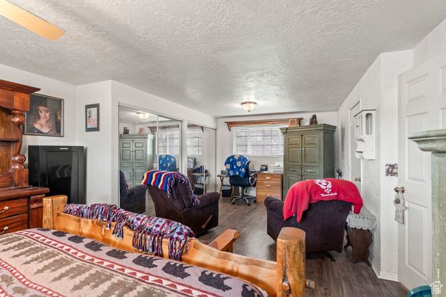 Living area with a textured ceiling and dark wood finished floors | Image 13
