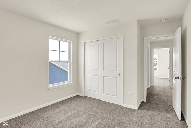 unfurnished bedroom with multiple windows, carpet flooring, visible vents, and a closet | Image 34
