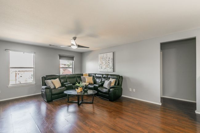 Living room with ceiling fan and wood finished floors | Image 17