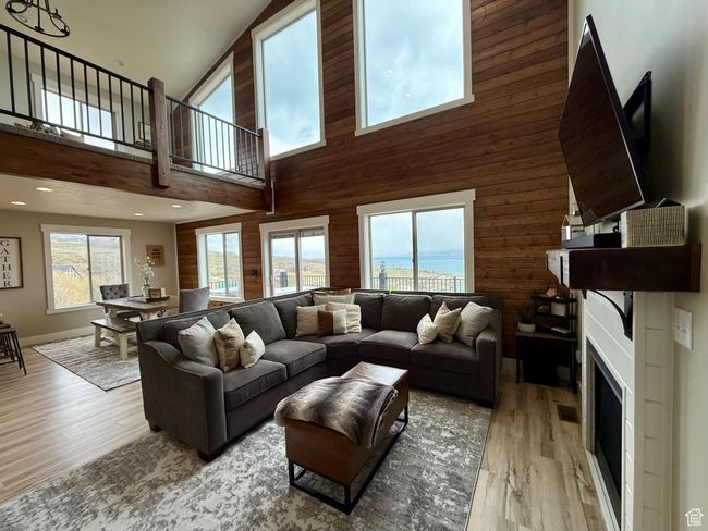 Living area with light wood-style floors, plenty of natural light, and a towering ceiling | Image 17