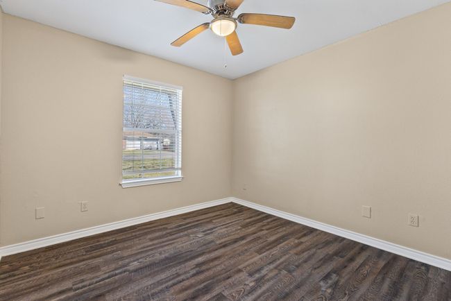 Spare room with dark wood-style floors, ceiling fan, and baseboards | Image 22