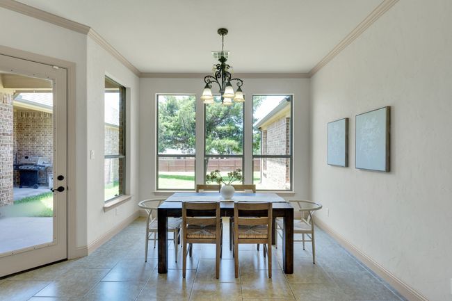 Dining space with plenty of natural light, a chandelier, light tile patterned flooring, and ornamental molding | Image 8