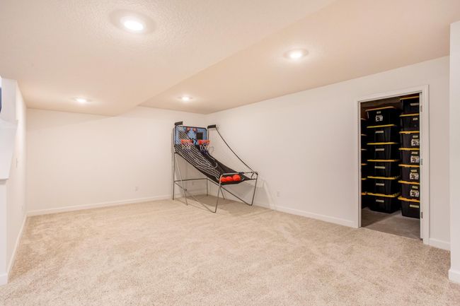 Dedicated amusement room currently staged for recreation, with access to a large storage room. | Image 36