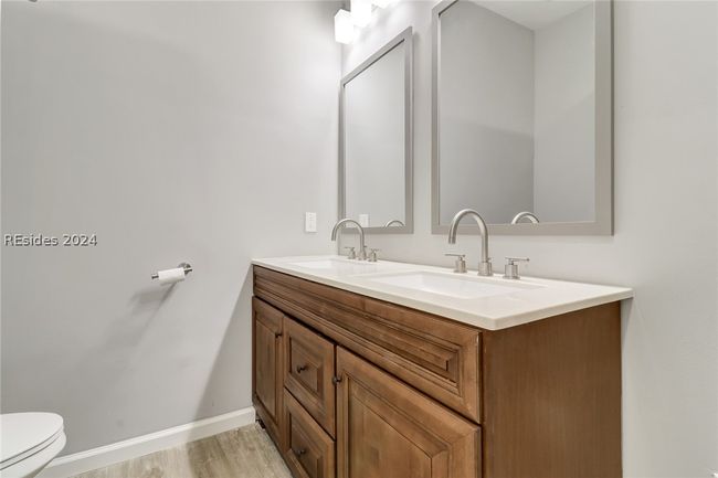 Bathroom featuring dual vanity, toilet, and hardwood / wood-style floors | Image 25