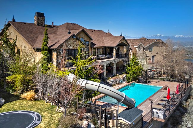 View of pool featuring fence, a patio, a water slide, and a fenced in pool | Image 9