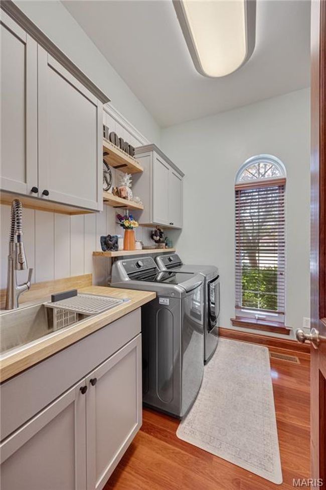 Washroom with washing machine and dryer, cabinet space, and light wood-type flooring | Image 44