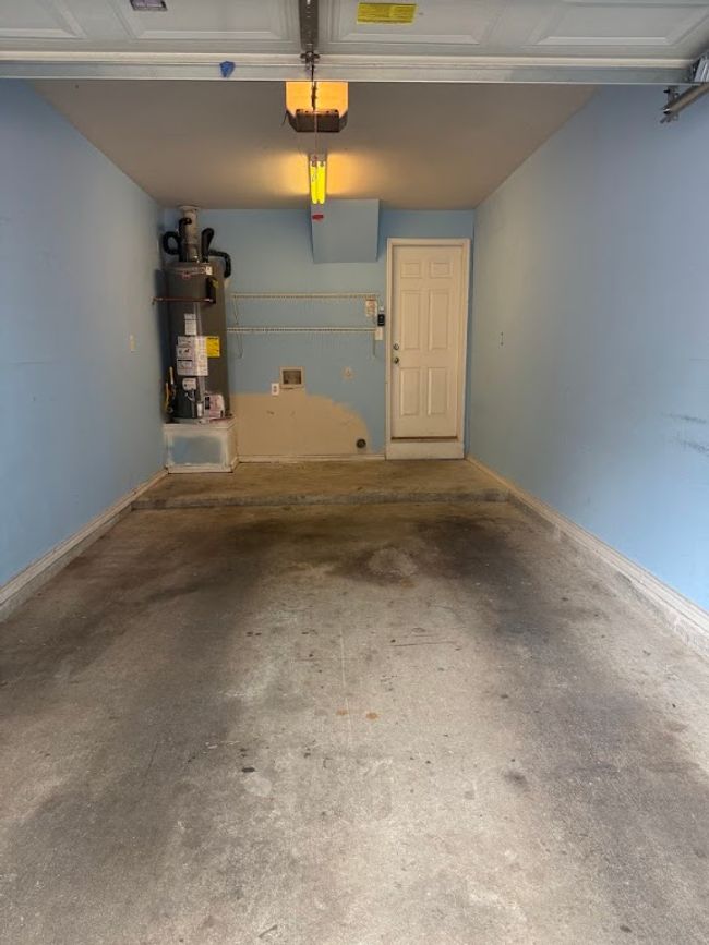 Garage featuring water heater and a garage door opener | Image 29