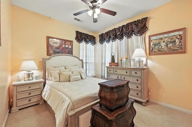 Bedroom featuring light colored carpet and ceiling fan | Image 15