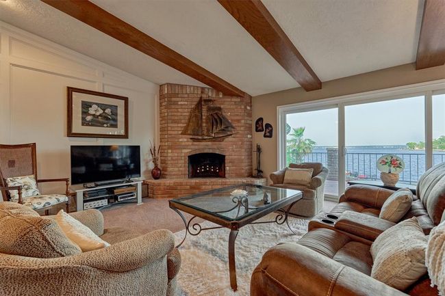 A wood-burning fireplace creates a warm, inviting ambiance on cooler nights, perfectly complemented by unobstructed views of the lake beyond. | Image 10