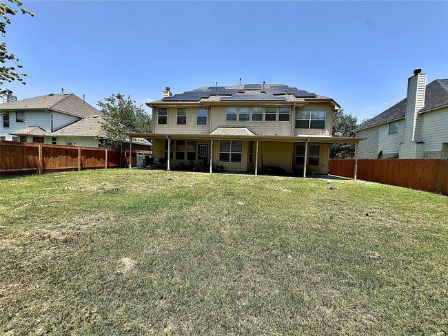 Rear view of property with roof mounted solar panels, a patio, and a chimney | Image 36
