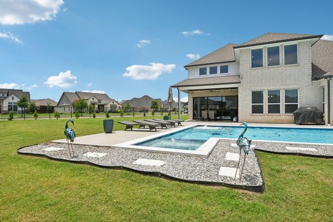 View of swimming pool featuring grilling area, an in-ground hot tub, a patio, and a residential view | Image 38