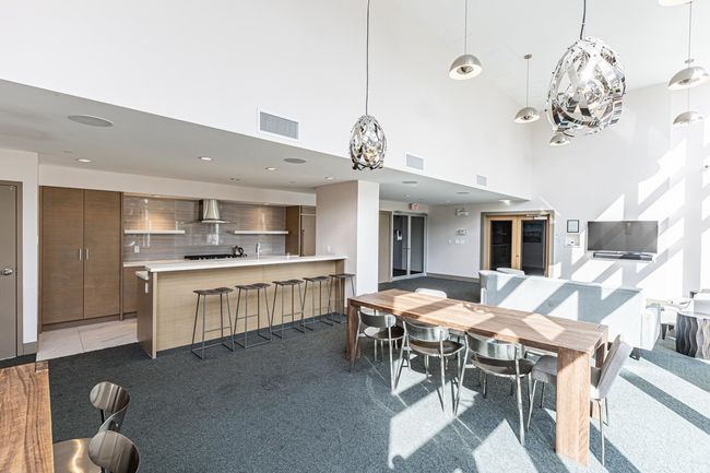 Dining area featuring a towering ceiling, light carpet, and a chandelier | Image 20