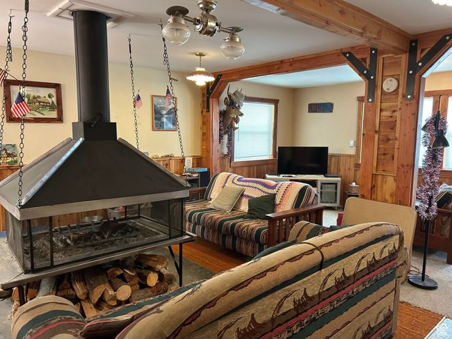 Carpeted living area featuring a wainscoted wall and wood walls | Image 15