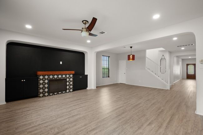 Unfurnished living room with visible vents, ceiling fan, and wood finished floors | Image 17
