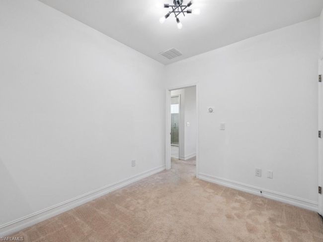 Carpeted empty room with an inviting chandelier | Image 14