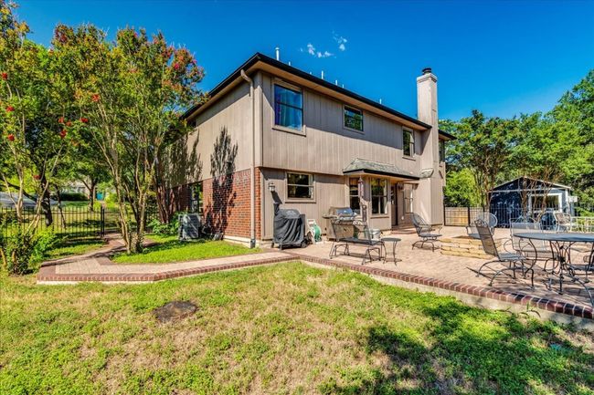 Sprawling back patio with fire pit overlooks greenbelt backyard setting and offers the perfect area for relaxation or entertaining! | Image 33