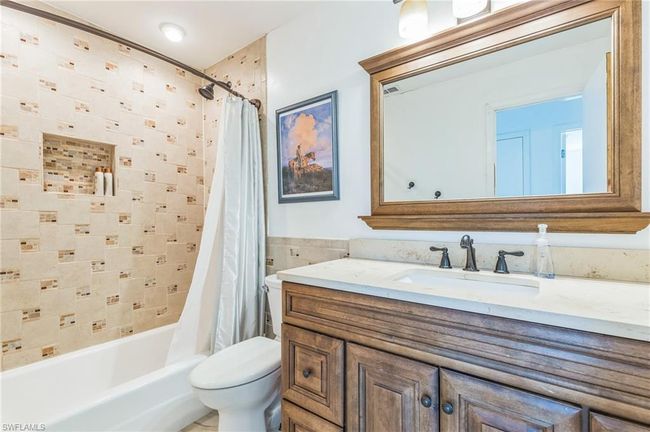Bathroom featuring vanity, shower / tub combo with curtain, toilet, and tile walls | Image 27