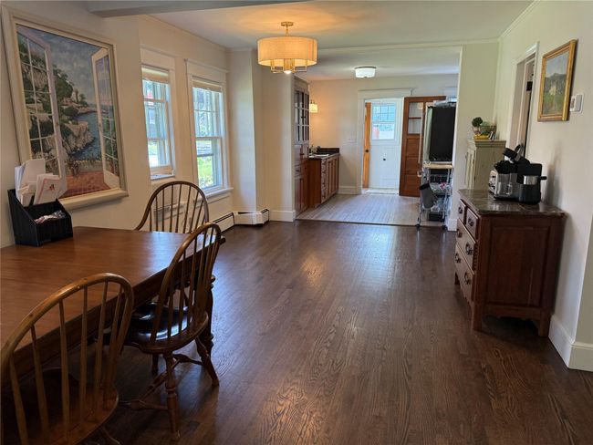 Dining space with dark wood-style floors, ornamental molding, and a baseboard heating unit | Image 5