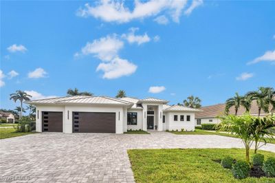 Stunning frontal view of home with 3 car garage and oversized circular driveway with brick pavers | Image 1