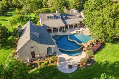 Imagine lazy summer days alongside this 88, 000-gallon heated multi-level pool by Omega Pools, featuring a spa, remote controls, a PebbleTec finish and an 8-foot deep end. | Image 1