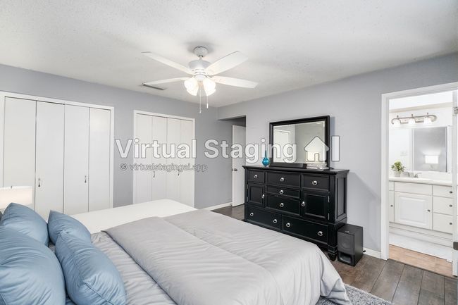 Bedroom featuring ensuite bathroom, dark wood-style flooring, two closets, and a textured ceiling | Image 20