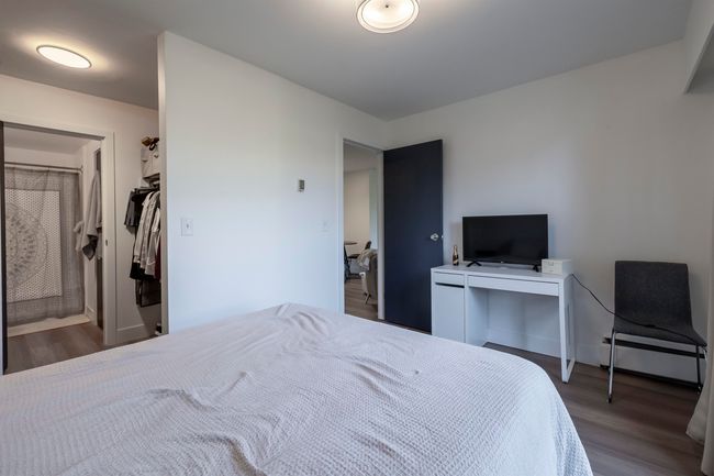 Bedroom with a baseboard heating unit and wood finished floors | Image 19